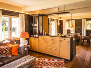 Golden Hill Country Chalets & Suites Wohnbereich mit großem Tisch, Sesseln und Sofa