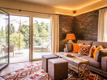 Golden Hill Country Chalets & Suites Wohnzimmer mit Sofa und Balkon